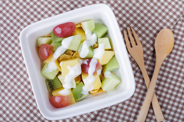 Bowl of healthy fresh fruit salad with yogurt. Top view.