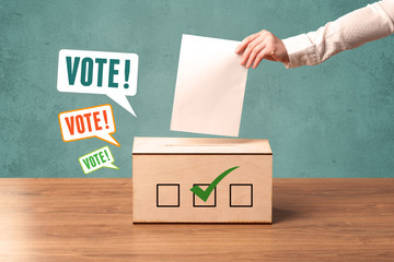 placing a voting slip into a ballot box