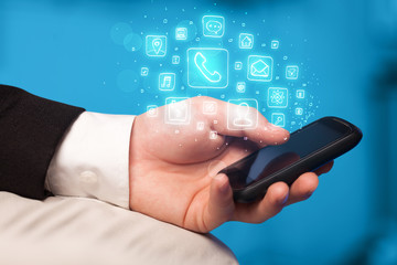 Hand holding smartphone with mobile app icons