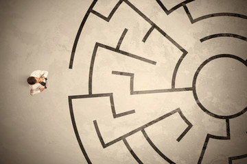 Lost business man looking for a way in circular labyrinth