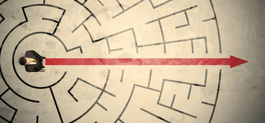Business person standing in the middle of a circular maze