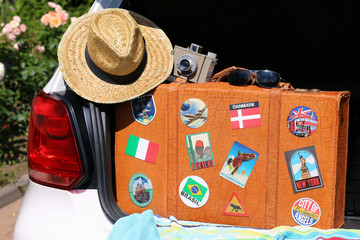 Alter Reisekoffer mit Aufklebern im Kofferraum
