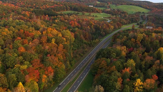 Flying above curving road through New York countryside