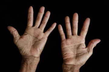 The old woman's hands on black background