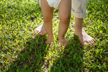 Portrait of mother and baby legs. First steps.