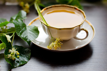 porcelain Cup of Linden tea on a background of dark wood