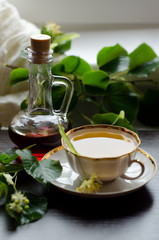 porcelain Cup of Linden tea and Maple syrup on a background of dark wood