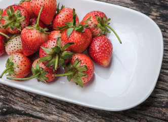 Small white filled with succulent juicy fresh ripe red strawberr