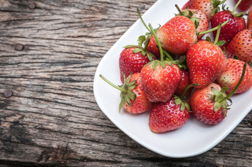 Small white filled with succulent juicy fresh ripe red strawberr