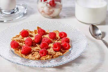Wheat flakes with raspberries and milk.