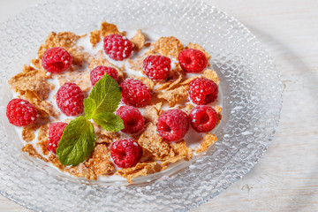 Wheat flakes with raspberries and milk.