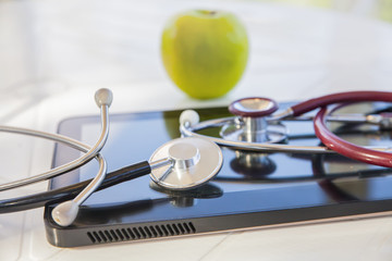 green Apple, medical stethoscope and pill tablet, still life on the theme of diet