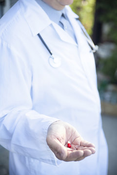 closeup medical pill in the hand of the doctor