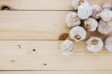 Fototapeta na wymiar Organic garlic whole and cloves on the wooden background