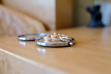 Beautiful wedding rings for bride and groom. Beauty of wedding accessories indoors. Close-up bridal jewel of marriage. Female and male decoration for couple. Jewelry for man and woman