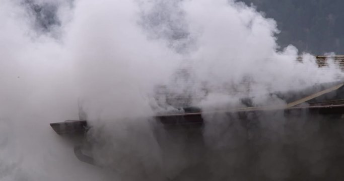 Heavy white smoke escaping from around the gutter of a burning house