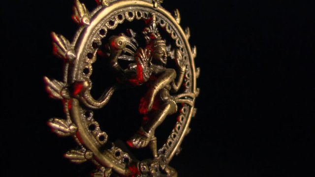 Encircled golden image of Shiva with red highlights rotating on black frame