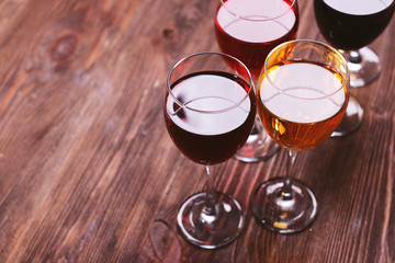 Glasses with wines of different colors on a wooden table
