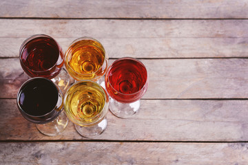 Glasses with wines of different colors on a wooden table