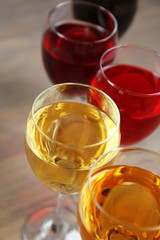 Glasses with wines of different colors on a wooden table