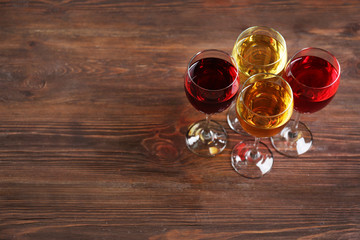 Glasses with wines of different colors on a wooden table