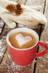 Cup of coffee with marshmallow on wooden table