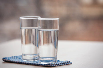 Two glasses of pure water on blurred background