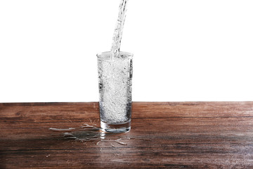 Pouring water into glass on wooden table