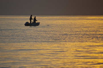 Pescadores en el mar al amanecer