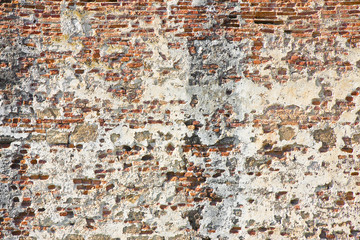 Old italian stone and brick wall with degraded plaster