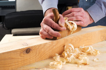 Carpenter working with plane on wooden background. Copy space