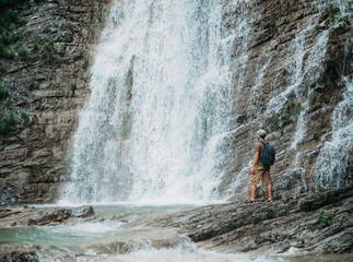 Hiker man looking at waterfall