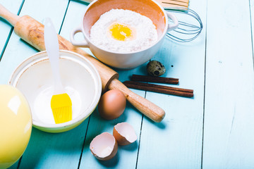 Preparation of the dough. Ingredients for the dough - Eggs and flour with a rolling pin. On wooden background.