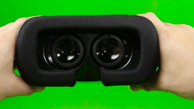 Male hand taking a virtual reality headset. Virtual reality mask. Green screen. Close up