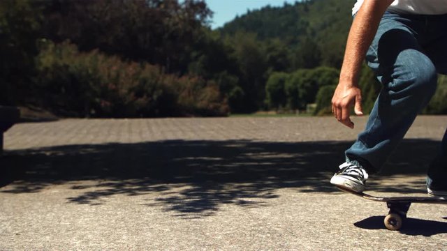 Ultra-slow motion shot of skateboard trick, skateboarder shown from hips down