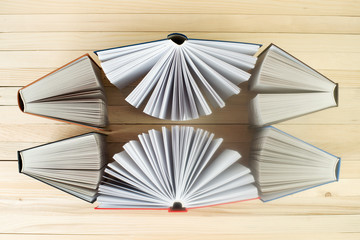 Open book, stack of hardback books on wooden table. Back to school. Copy space