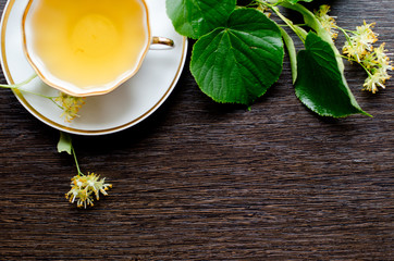 porcelain Cup of Linden tea on a background of dark wood
