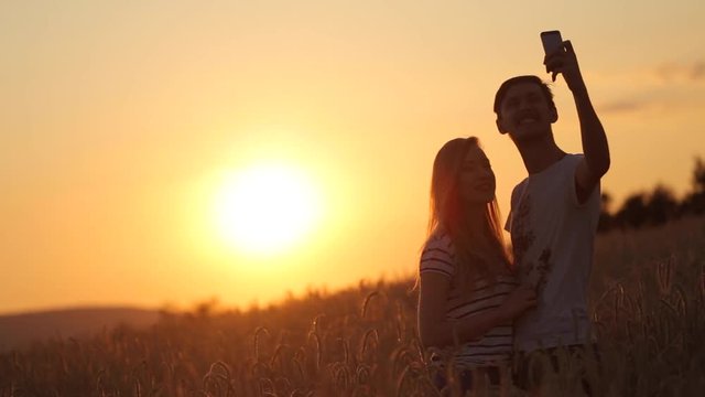 selfie shoot a girl with a guy at sunset slow motion video