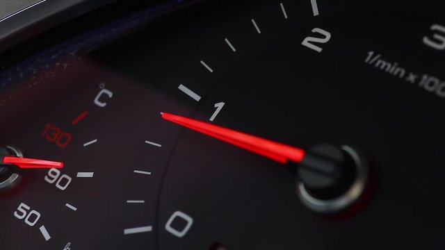 Close up footage of a car's tachometer reving.