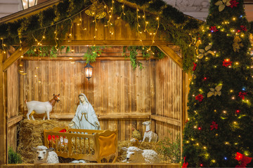 Obraz premium Nativity scene with Holy family of Joseph, Mary, baby Jesus Christ and sheep, holiday decorations in the Old Town in the magical city of Prague at night, Czech Republic