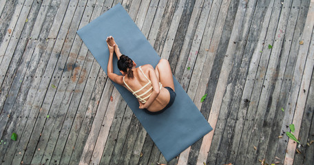 Asian young woman doing yoga on wooden floor