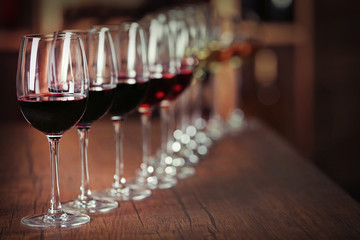 Many glasses of different wine in a row on bar counter