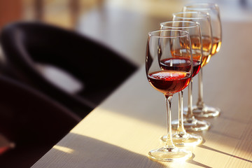 Many glasses of different wine in a row on a table