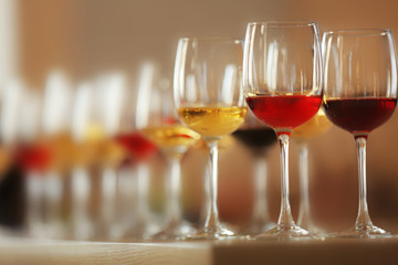 Many glasses of different wine in a row on a table