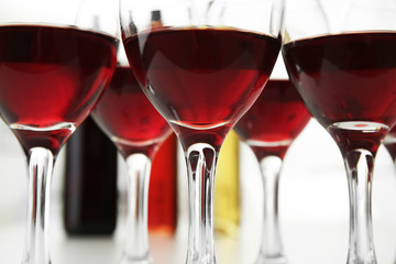 Glasses of red wine on white table closeup