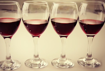 Glasses of red wine on white table closeup
