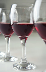 Glasses of red wine on white table closeup