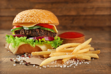 Hamburger with fries on wooden background