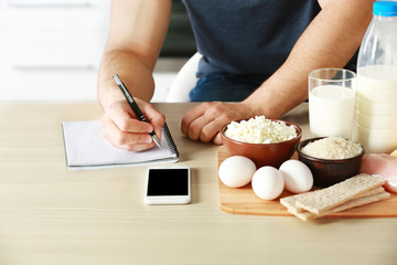 Man counting calories on table