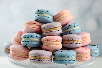 Tasty macaroons on stand on wooden table